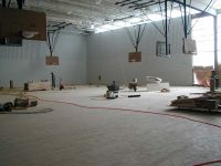 Wood flooring and basketball hoops have been installed in the gymnasium.