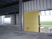 On the north side of the middle school, the metal stud framing is being covered with yellow dens board.