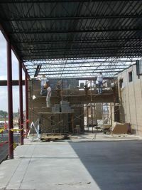 Construction workers erect masonry walls.