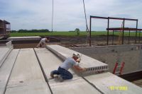 A precast concrete plank is lowered into place.