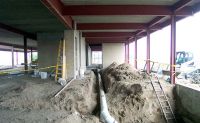 Pipes are installed on the first floor of the three-story wing of the school.