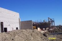 Construction workers build a masonry wall on the south side of the middle school near the cafetorium.